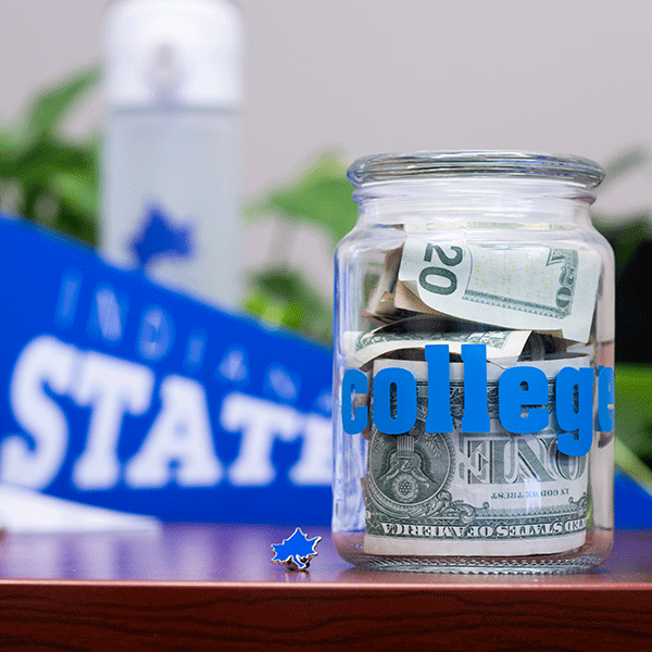 A jar filled with United States currency on a table with a blue Indiana State University penant in the background.