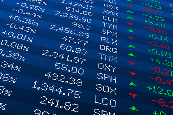 An image of a digital screen with rows of text – including percentages and company name abbreviations – appearing in white lettering, with a row on the far right in green and red lettering. Green and red triangles are visible in the row to the left, with some triangles pointing up and others pointing down.