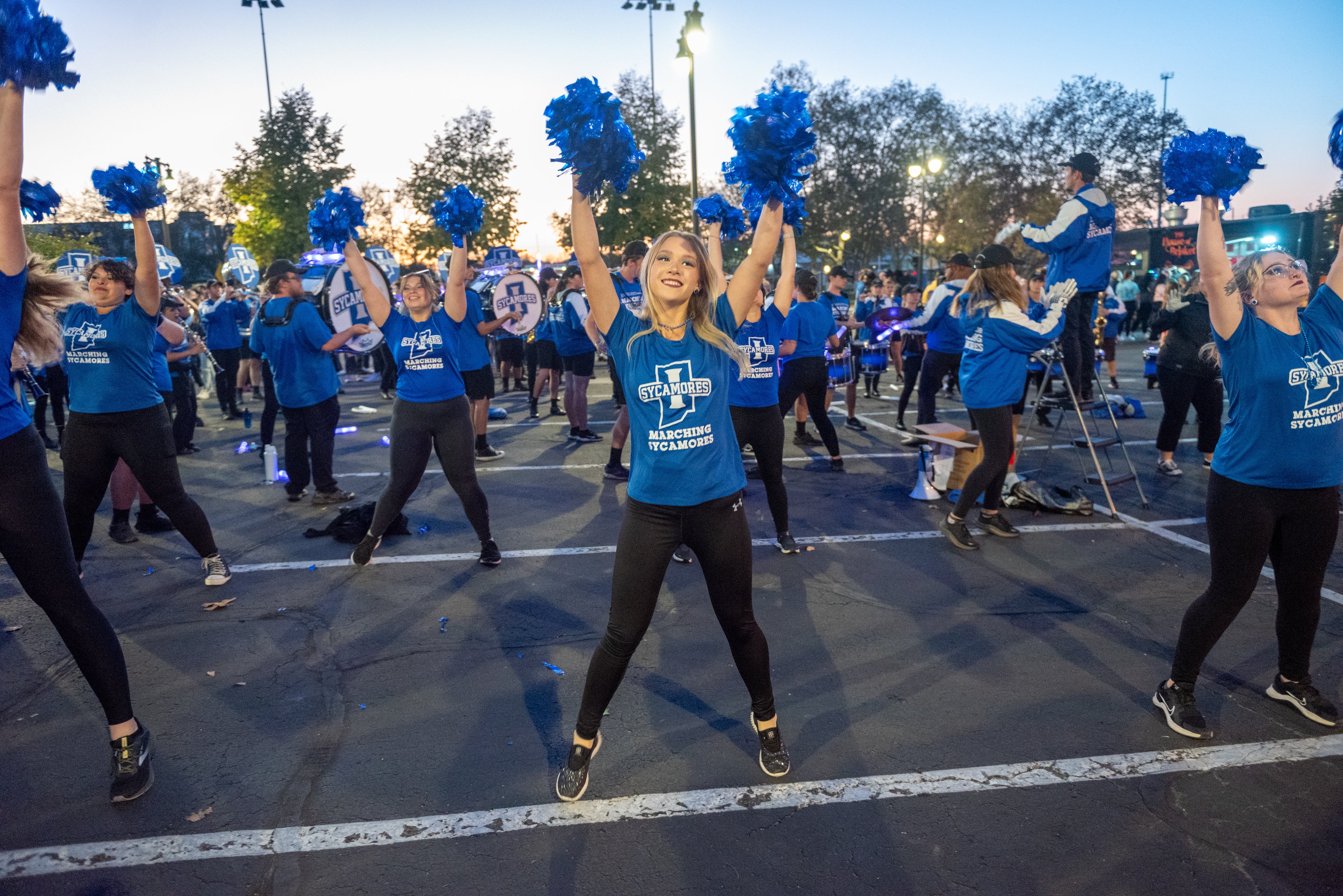 Sycamore marching band members and colorguard members performing
