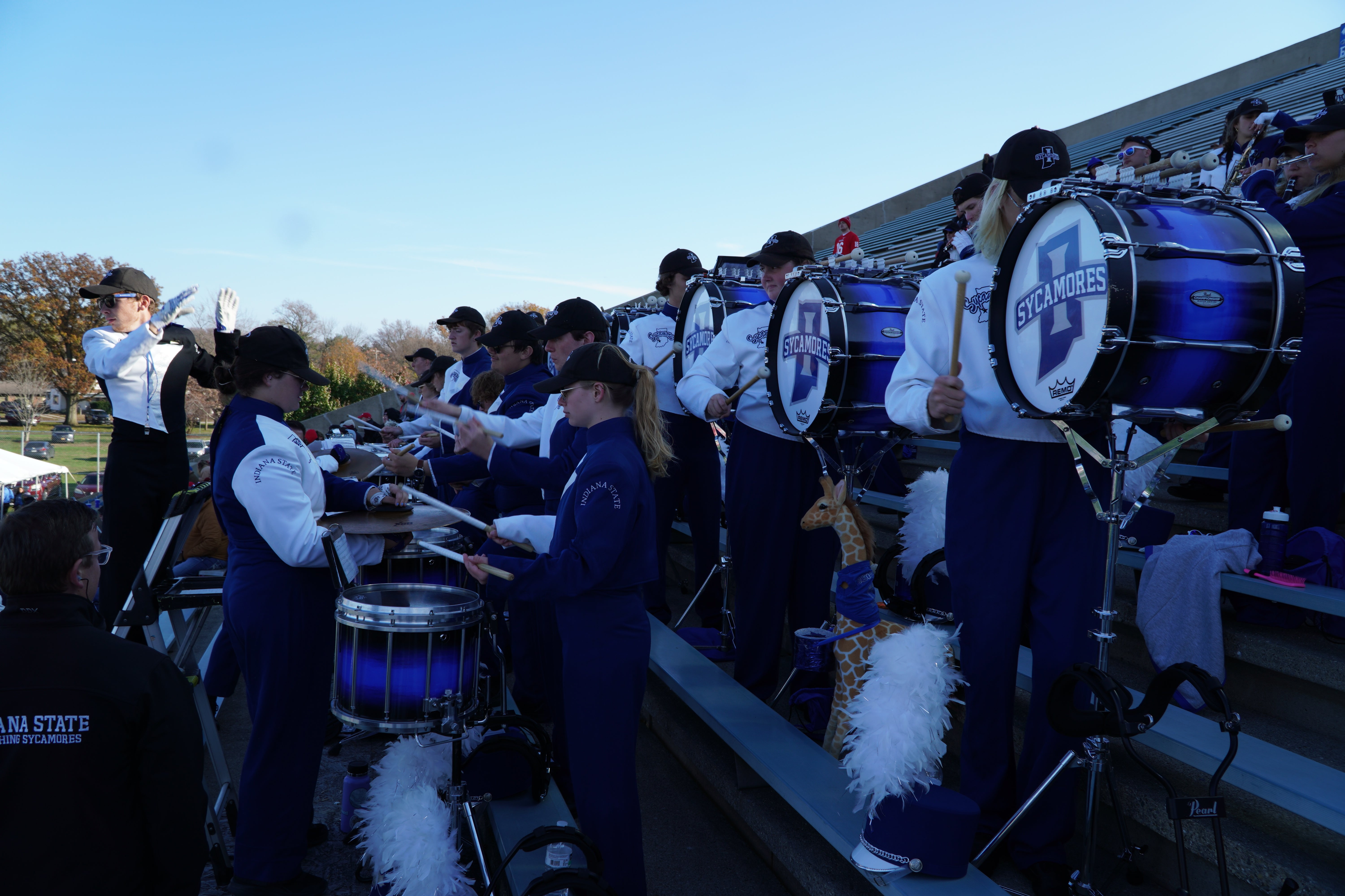 Sycamore Drum Members playing drums on stadium bleachers.
