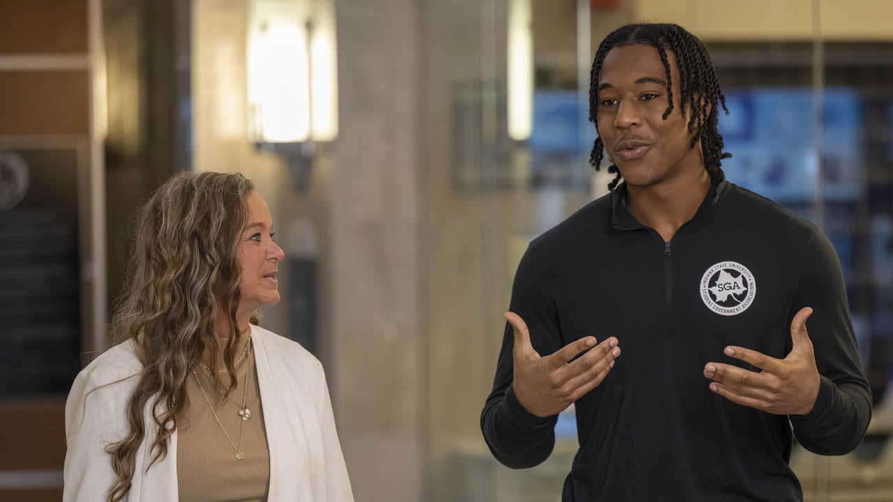 Student Government Association member speaks with a woman during a conversation on campus.