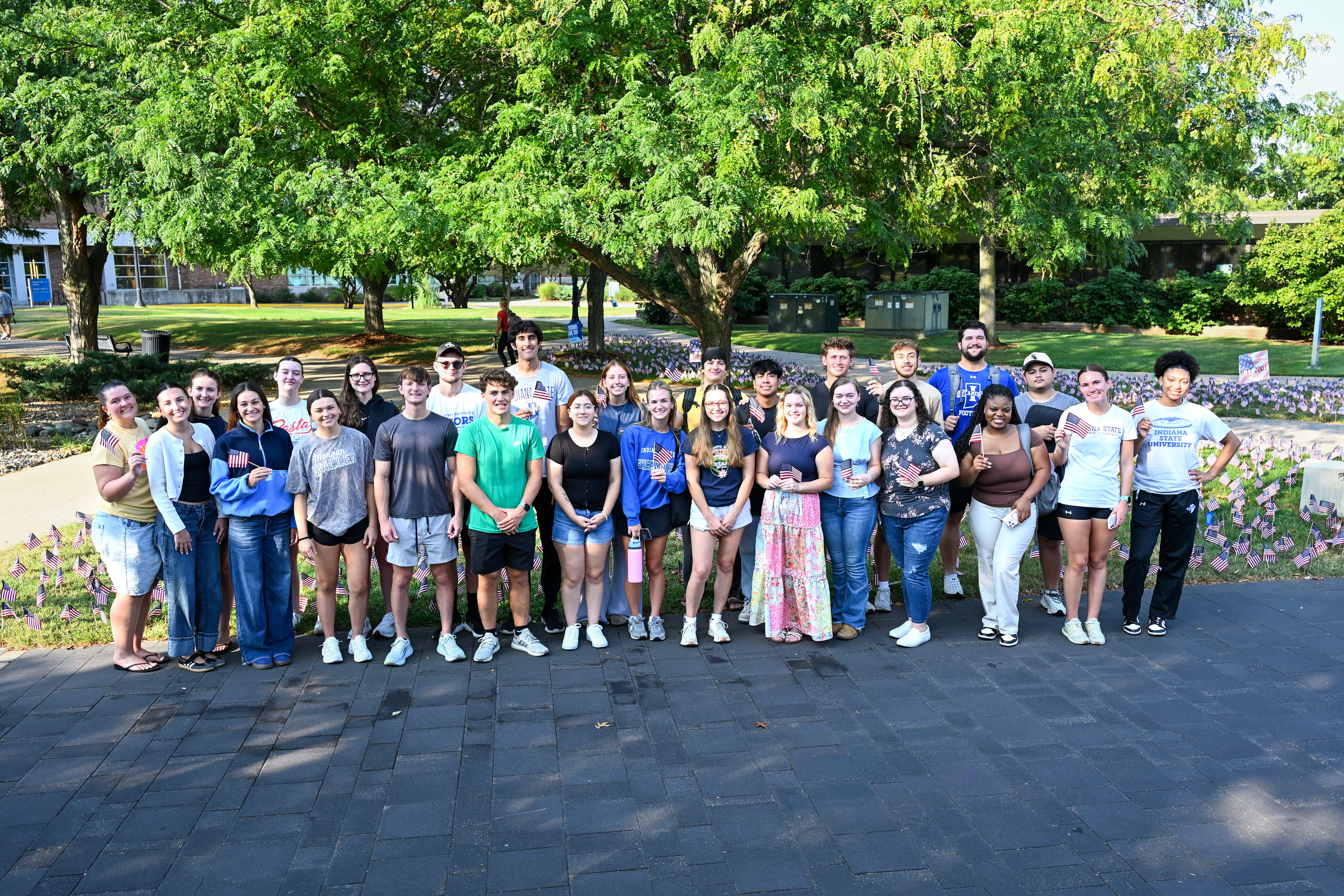 Group of ISU students standing in front of the flags they placed