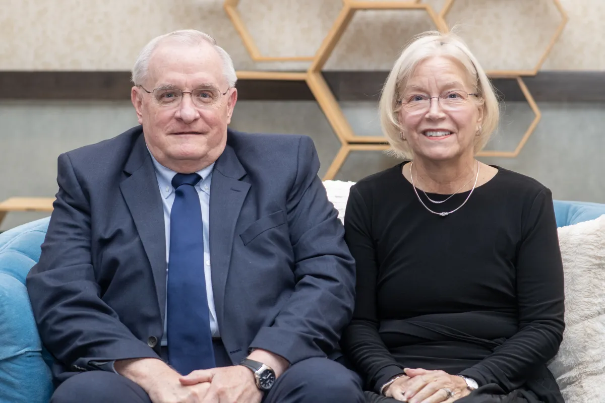 Jerry Cockrell (left) and Jan Cockrell (right) sit side by side on a sofa. 