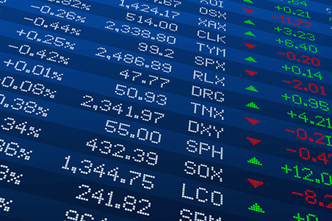 An image of a digital screen with rows of text – including percentages and company name abbreviations – appearing in white lettering, with a row on the far right in green and red lettering. Green and red triangles are visible in the row to the left, with some triangles pointing up and others pointing down.